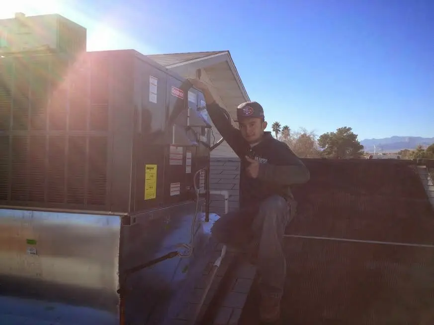 HVAC technician performing AC Tune-Up on a rooftop unit in Home Gardens